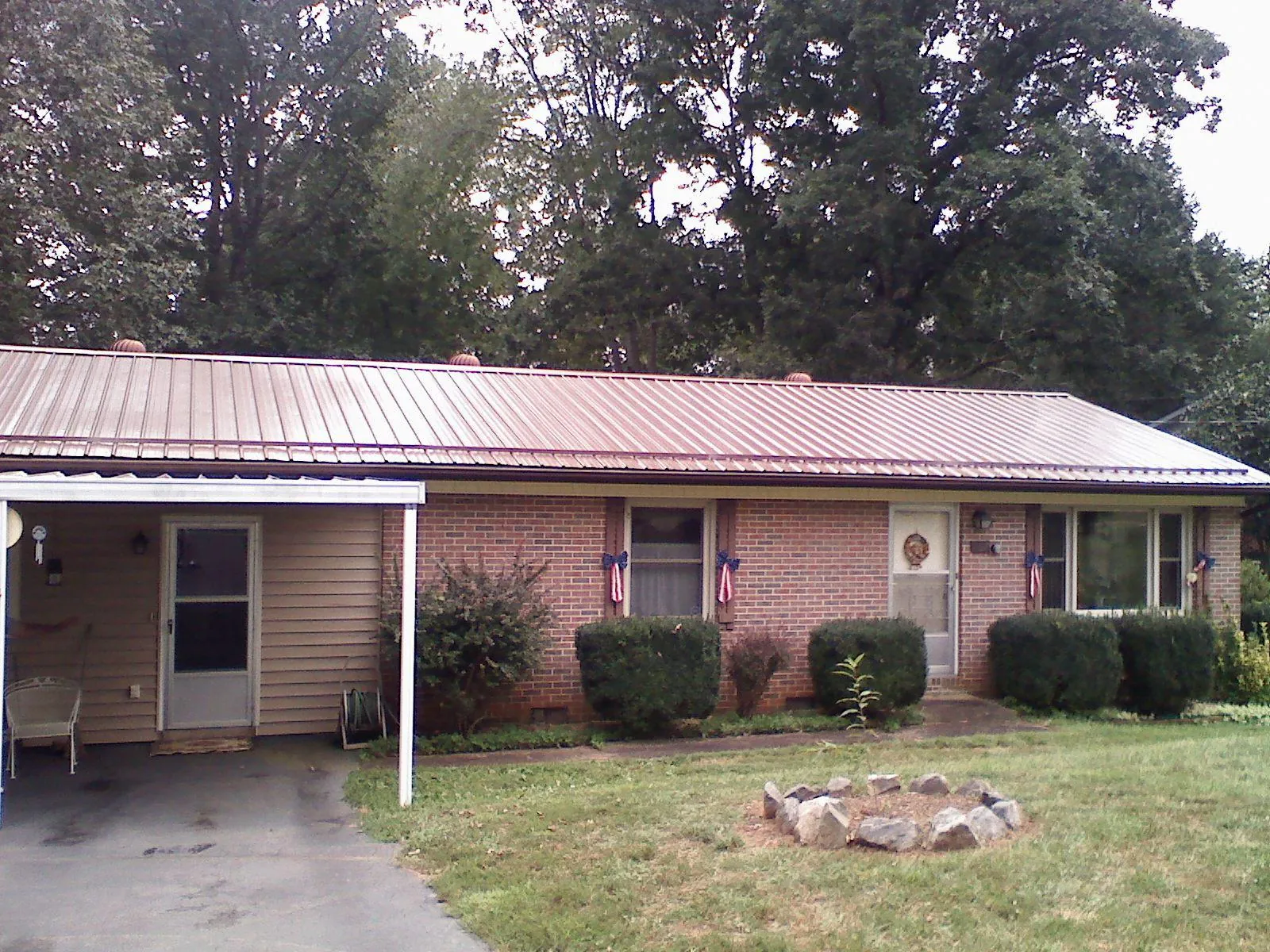 Bronze metal roof and carport on a brick ranch home — Roof Repair work by our crew in Rowesville