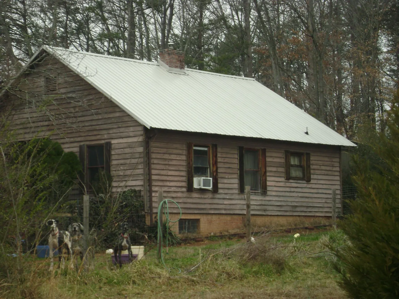 White metal roof on an old wood sided farmhouse, from a Metal Roof Installation job in Rowesville